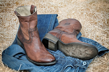 Leather cowboy boots and jeans on straw