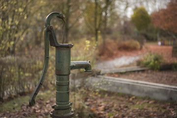 Hand pump in the autumnal garden