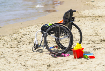 sedia a rotelle di un bambino sulla spiaggia