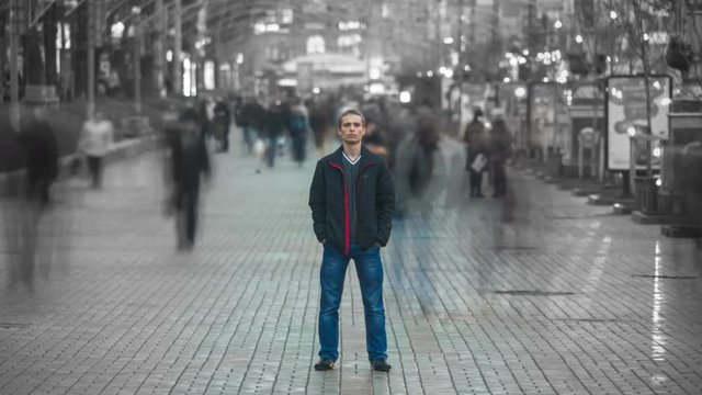 Man stand in the smash ghost crowd stream at the city street. Concept time lapse