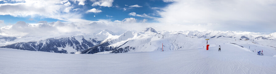 Fototapeta na wymiar Ski slopes and skiers skiing in Kitzbühel ski resort in Tyrolian Alps, Austria