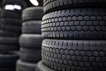 Tires for sale at a tire store - stacks of old used tires - obrazy, fototapety, plakaty