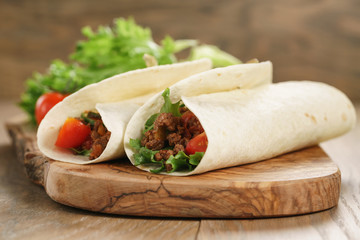 homemade tortilla with beef, frillice and vegetables on wooden board