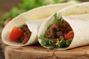 homemade tortilla with beef, frillice and vegetables on wooden board
