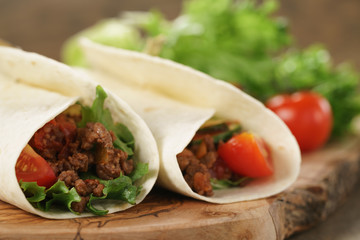 homemade tortilla with beef, frillice and vegetables on wooden board