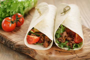 homemade tortilla with beef, frillice and vegetables on wooden board