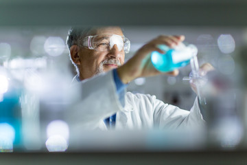 Senior male researcher carrying out scientific research in a lab