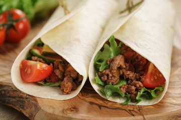 homemade tortilla with beef, frillice and vegetables on wooden board
