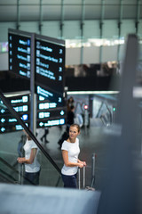 Young female passenger at the airport, transfering to her gate