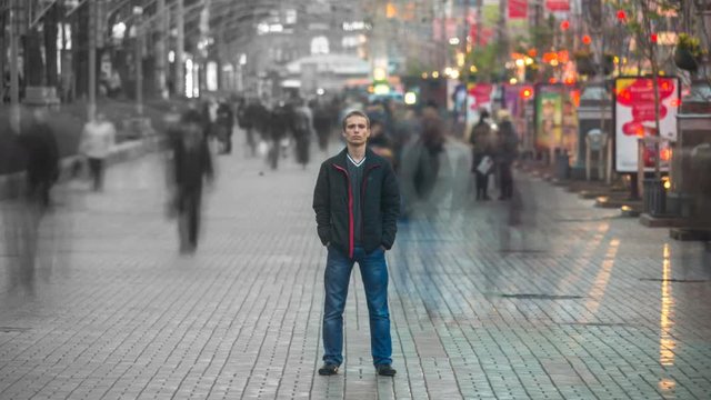 Man stand in the smash ghost crowd stream at the city street. Concept time lapse
