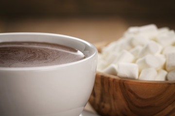 hot chocolate in cappuccino cup with marshmallows on wood table