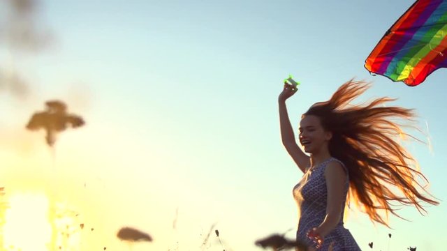 Beauty girl in short dress running with kite on the field. Freedom concept. Slow motion 240 fps, HD 1080p