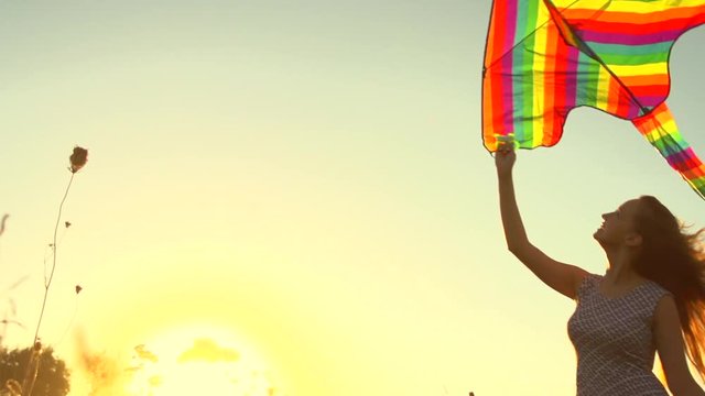 Beauty girl in short dress running with kite on the field. Freedom concept. Slow motion 240 fps, HD 1080p