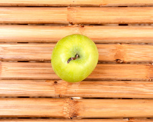 Organic granny smith apple on natural bamboo table