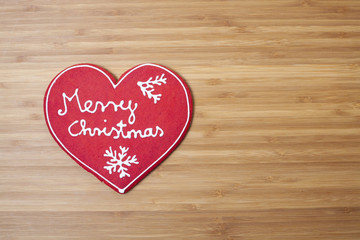 Christmas heart shaped decoration on wooden background with plen
