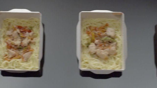 Noodles Thai. Hands put on the tabble boxes with noodles