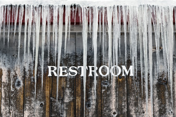 Outdoor Bathroom with Icicles hanging from it in Winter