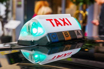 taxi sign on the roof of a Parisian taxi - obrazy, fototapety, plakaty