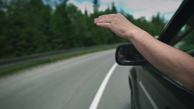 Hand out the window of a moving vehicle