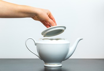 Elegant porcelain white jug and woman hand