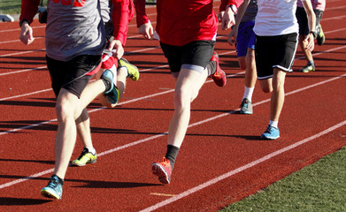 group running on a track in spikes