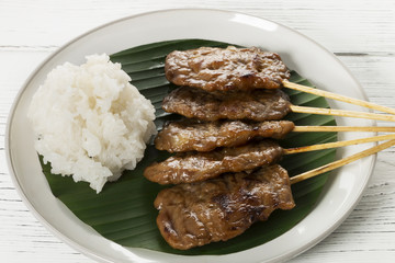 grill pork with sticky rice on wood background