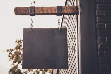 blank rusty metal plate  hanging on wood bar