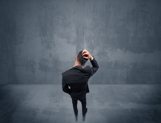 Businessman standing in front of urban wall