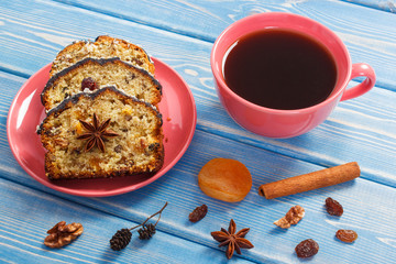 Cup of coffee and fresh baked fruitcake on boards