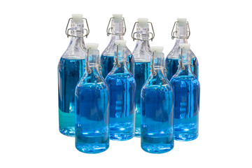 Glass bottles with blue water isolated on white background.