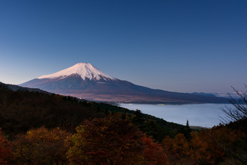 雲海の上、朝日に赤く染まる富士山