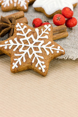 Obraz na płótnie Canvas christmas decoration. homemade gingerbread cookies and red berries on wrapping paper background.