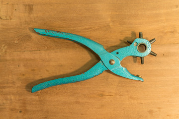 Leather Hole Punch Tool on wooden background - hole punch for leather goods
Old blue Multiple revolving diameters puncher.