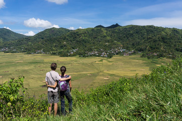 Fototapeta na wymiar Tourists enjoying the view over the spider web rice fields, Cancar, Ruteng, Flores, Indonesia