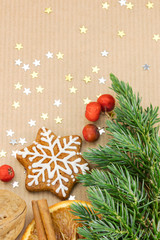 christmas cookies, spices, nut and red berries on brown wrapping paper background 