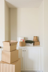 Variety of Packed Moving Boxes and Materials In Empty Room.