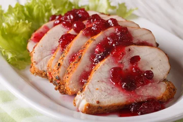 Poster Sliced roasted turkey breast with cranberry sauce close-up. Horizontal © FomaA