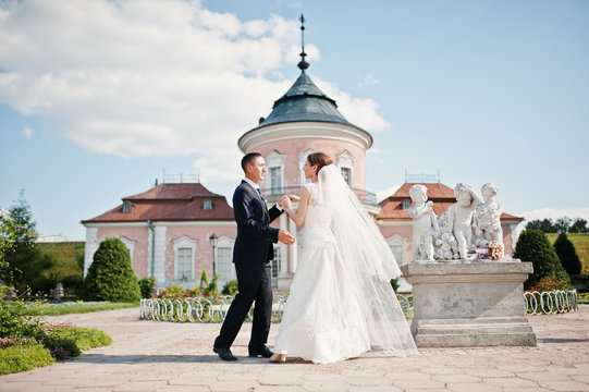 Wedding Couple At Yard Of Old Mansion With Monument Of Three Boy