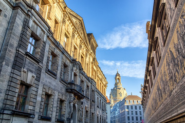 Fototapeta premium City center of Dresden, Germany, with historic buildings and the Fuerstenzug (Procession of Princes), a giant mural, with famous Frauenkirche in the background.