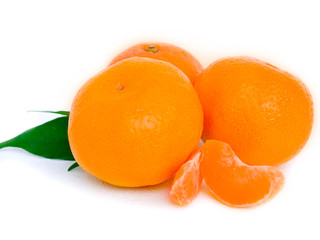 Tangerines with leaves and slices on white background