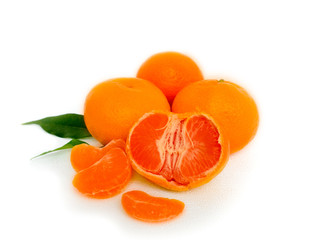 Tangerines with leaves and slices on white background
