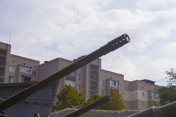 Artillery Gun Muzzles on Background of Residential Buildings