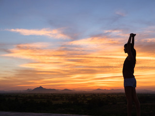 Young woman enjoying outdoors, sky background,sunset