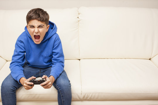 Little Boy Playing Videogame On The Couch