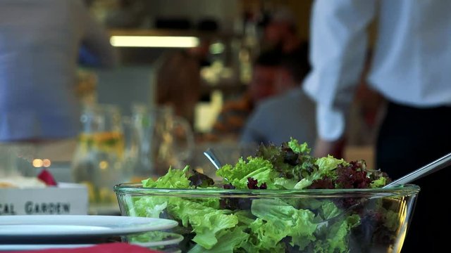 detail of salad on the table in the restaurant - people talk in the background