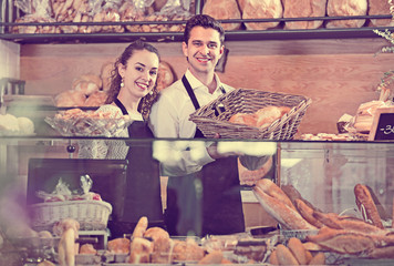 Portrait of friendly young  smiling couple at bakery display