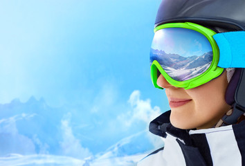 A mountain range reflected in the ski mask. Girl wearing a ski mask