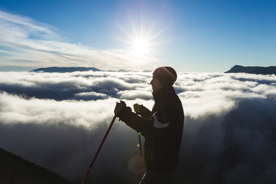 Silhouette of a climber high in the mountains above the clouds a