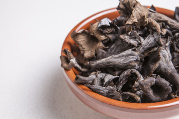 Clay bowl full of Horn of Plenty mushrooms