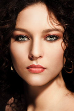 Brunette girl with a curly hairstyle, modern make-up and carnivore look